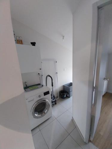 a white laundry room with a washing machine in it at Gîte La Caillère in Moncoutant