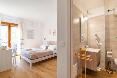 a bedroom with a bed and a bathroom at Stentadì Guest House Tortolì in Tortolì