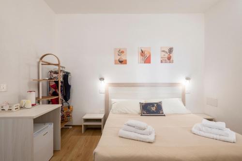a bedroom with a bed with towels on it at Stentadì Guest House Tortolì in Tortolì