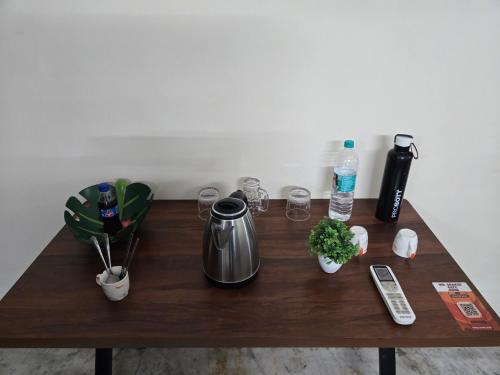 a wooden table with a coffee maker and drinks on it at Gitanjali luxury in New Delhi