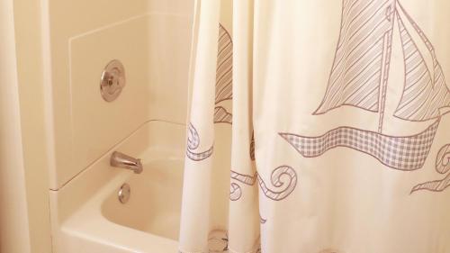 a bathroom with a shower curtain next to a tub at Relief Cape May Point in Cape May Point