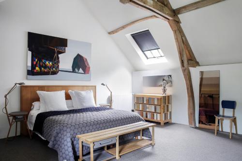 ein Schlafzimmer mit einem Bett und einer Bank darin in der Unterkunft Chateau De La Resle - Design Hotels in Montigny-la-Resle