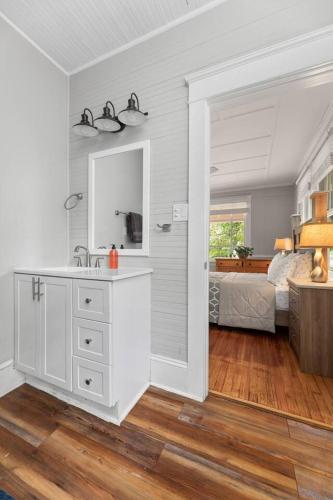 a white bathroom with a sink and a bedroom at Century-Old Remodeled Splendor in Salisbury