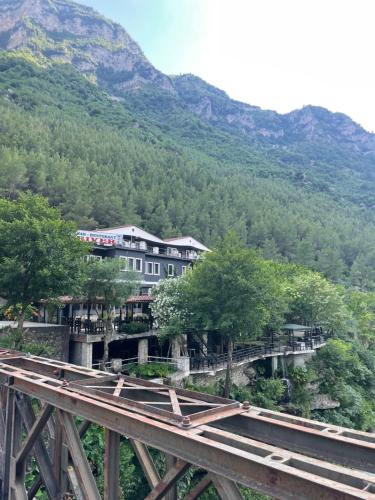 a building on a bridge with a mountain in the background at Bar-Restaurant-Hotel River in Këlcyrë Fshat
