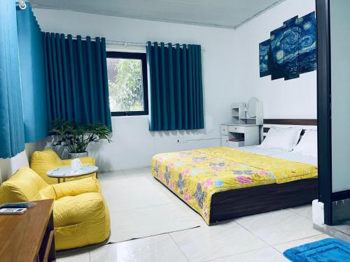 a bedroom with a bed and a yellow couch at Villa KimAnh in Sóc Sơn