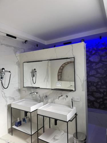 a bathroom with two sinks and a large mirror at Villa L'Ara in Capri