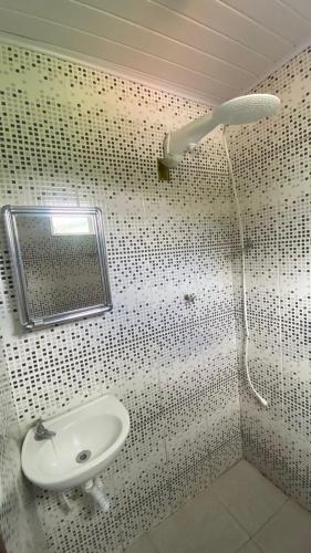 a bathroom with a shower with a sink and a mirror at Família Ebeneze in Santa Maria Madalena