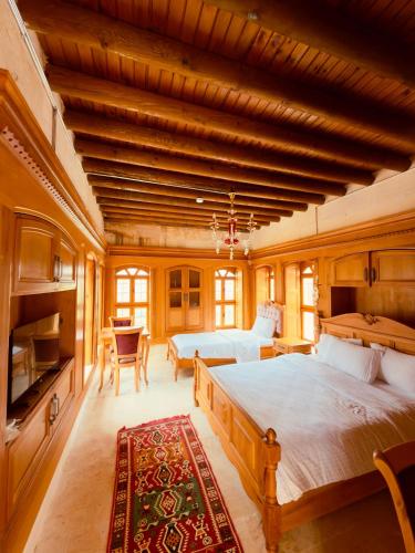 a large bedroom with two beds and a table at Yusuf Çavuş Konağı in Halfeti