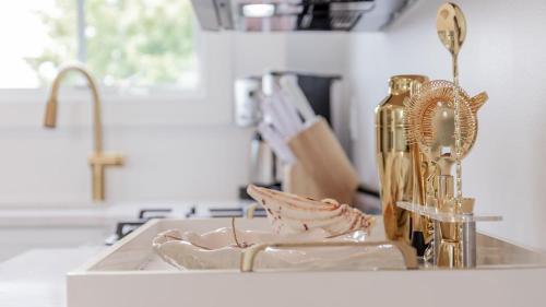 a kitchen counter with a sink with a gold faucet at The Ocean Loft At Kings in Cape May