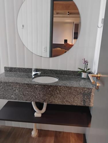 a bathroom with a sink and a mirror at FLAT Executivo próx Consulado Americano in Recife