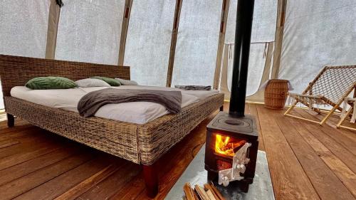 a bedroom with a bed in a tent with a stove at glamping podtrosky in Troskovice