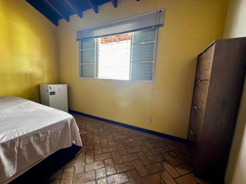a bedroom with a bed and a window and a dresser at Mega Suíte Na Melhor Localização in Botucatu