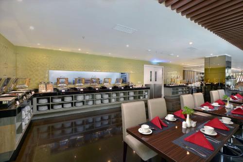 a restaurant with a table and chairs and a counter at Platinum Adisucipto Hotel & Conference Center in Yogyakarta