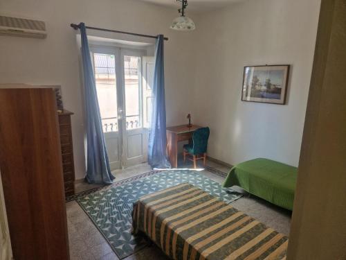 a bedroom with a bed and a door with a window at Brezza Marina in Bova Marina
