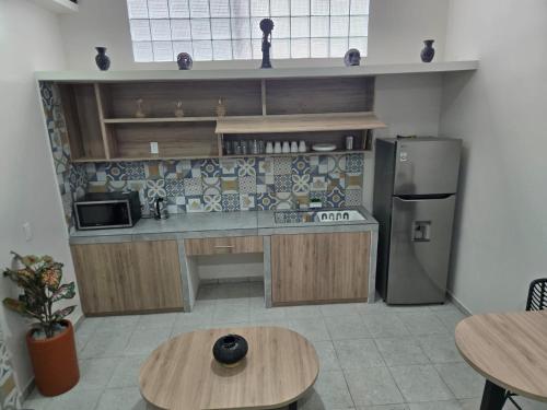 a kitchen with a counter and a refrigerator and tables at Oceania 198 cerca del Aeropuerto CDMX y Estadio GNP in Mexico City