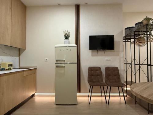a kitchen with a refrigerator and two chairs at Bianca Suites II in Bormujos