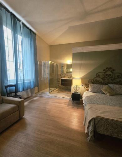 a bedroom with a bed and a chair and a couch at Aria di Mare - Tra Centro e Porto in Livorno