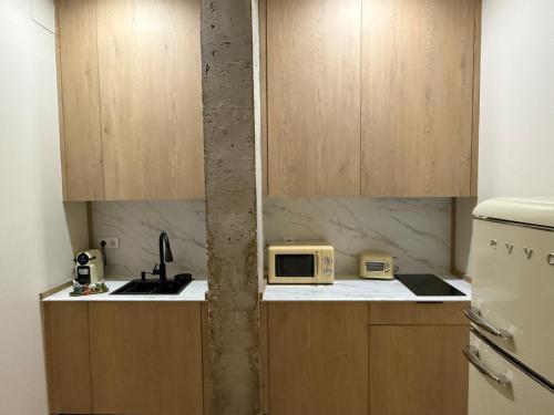 a small kitchen with a sink and a microwave at Bianca Suites III in Bormujos
