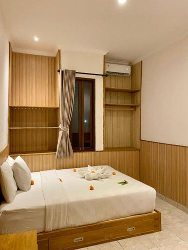 a bedroom with a large bed with white sheets at Dava Guest House Gianyar in Gianyar