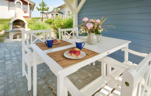 a white table with a plate of food on a patio at Seebrise B in Süssau
