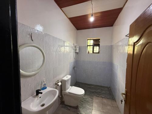 a bathroom with a toilet and a sink and a mirror at Eden house in Kigali