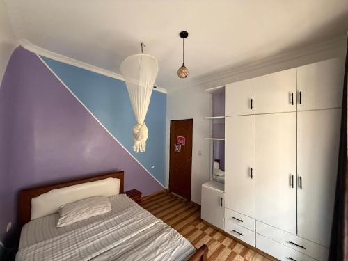 a bedroom with a bed and a purple wall at Eden house in Kigali