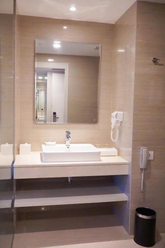 a bathroom with a sink and a mirror at Platinum Adisucipto Hotel & Conference Center in Yogyakarta