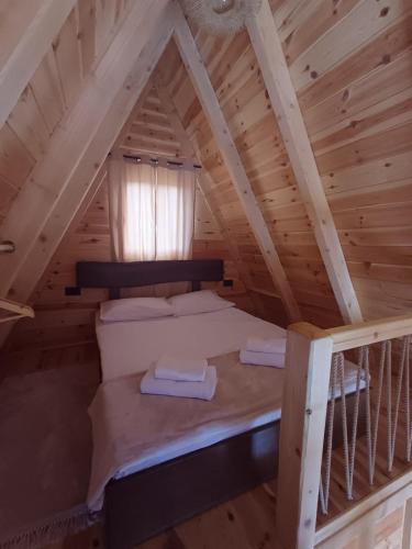 a loft bed in a log cabin with a window at Diva House in Nikšić