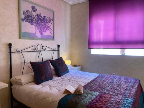 a bedroom with a bed with a book on it at Apartamento La Plazuela in Almagro