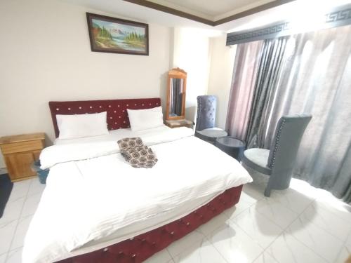 a bedroom with a bed and a chair and a window at Hotel Crown Palace in Dunga Gali