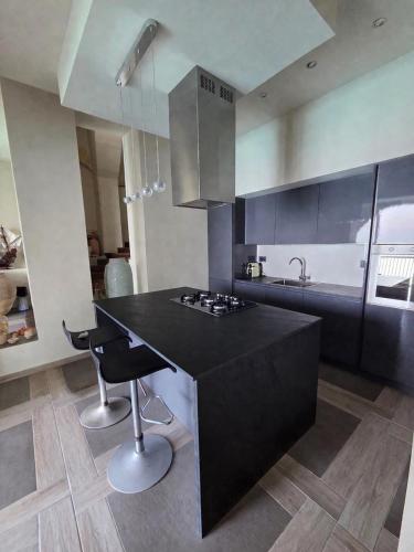 a kitchen with a black island with a counter top at Seaside Soul in Tropea