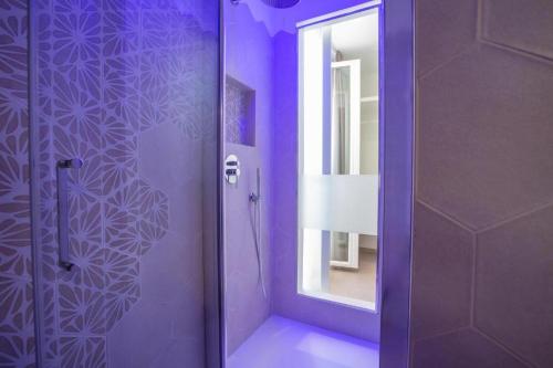 a purple bathroom with a shower and a mirror at Le Dune Luxury Rooms in Vieste