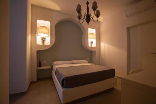a bedroom with a bed and two lights on the wall at Le Dune Luxury Rooms in Vieste