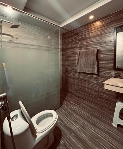 a bathroom with a toilet and a shower and a sink at SmartStay Residences in Rawalpindi