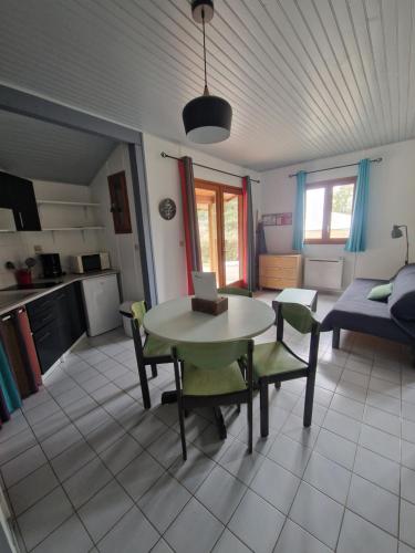 a kitchen and living room with a table and chairs at Chanteduc in Beaurières