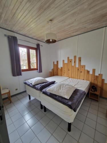a bedroom with a large bed with a wooden headboard at Chanteduc in Beaurières