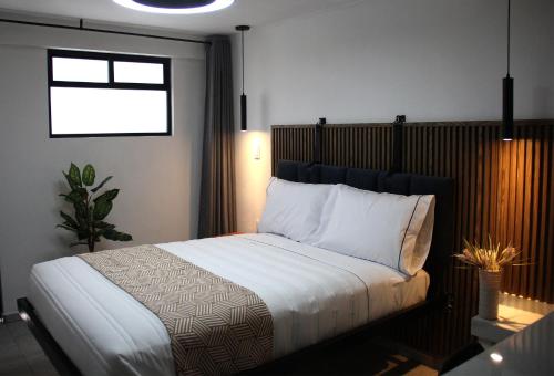 a bedroom with a bed with white sheets and a window at Oceania 198 cerca del Aeropuerto CDMX y Estadio GNP in Mexico City