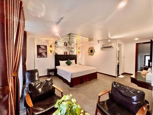 a hotel room with a bed and two chairs at Dinh Ami Hanoi Hotel in Hanoi