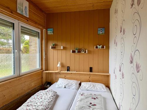 a bedroom with two beds and a window at Bungalow Marita in Julianadorp