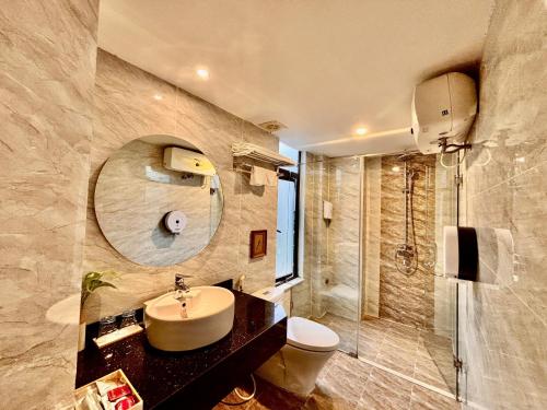 a bathroom with a sink and a toilet and a mirror at Dinh Ami Hanoi Hotel in Hanoi
