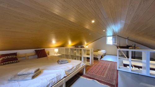 a room with two beds and a wooden ceiling at Casa Palmeiras, Seixal , Madeira in Seixal