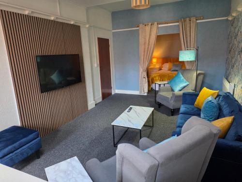 a living room with a blue couch and a tv at Beach Court Holiday Apartments in Skegness