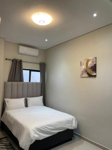 a bedroom with a bed in a room with a window at Premium View Guesthouse in Windhoek