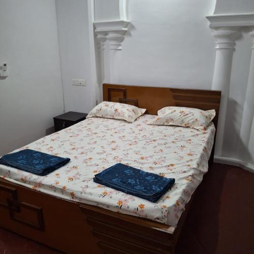 a bedroom with a bed with two pillows on it at Umbrella Guest House - Meenakshi Suite in Madurai