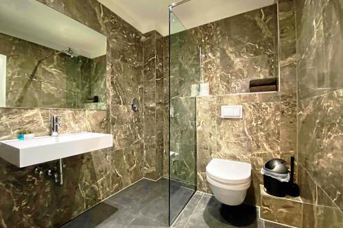 a bathroom with a toilet and a sink and a shower at MB Hotel in Bremen