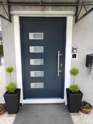 a black door with two potted plants in front of it at Green Home Bihać in Bihać