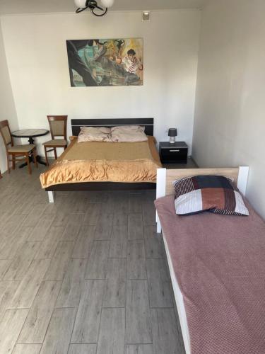 a bedroom with two beds and a table and chairs at U Karola in Darłowo