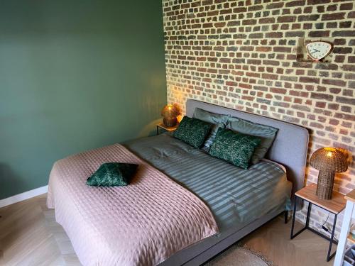 a bedroom with a bed against a brick wall at Gastenverblijf Het Groene Hart in Lanaken