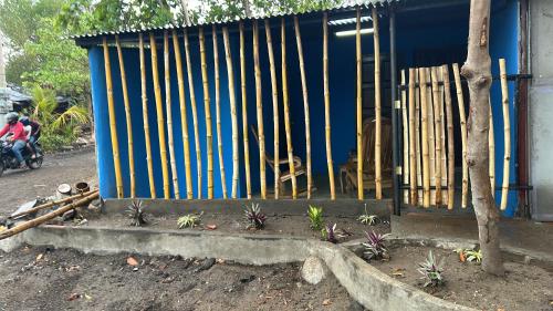 a blue building with a fence in front of it at Habitaciones Lala in Las Peñitas