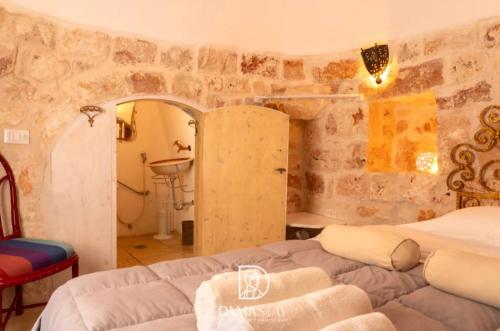 a bedroom with two beds in a room with stone walls at Trulli di Ivana in Ostuni